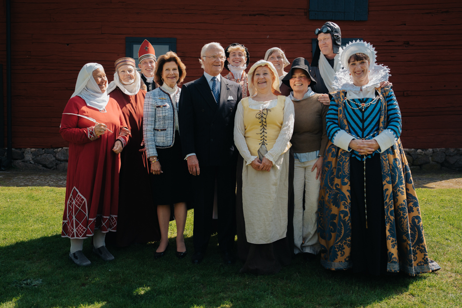 Kungaparet tillsammans med de historiskt klädda guiderna i slottsträdgården. 